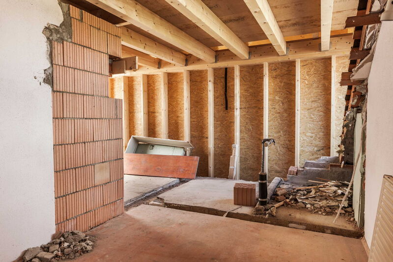 Aufriss einer gemauerten Wand. Teilweise freiliegende Decken und Seitenwände aus Holz.